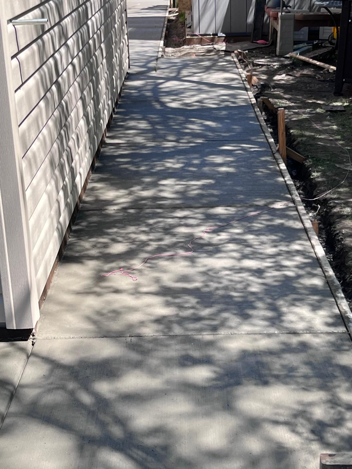Finished concrete sidewalk with tree shadows
